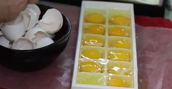 Той сложи пресни яйца във форма за лед